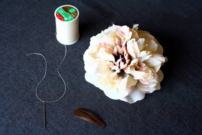 Đầu tiên, bạn cần 2 bông hoa hồng cài áo to bản (mua tại các cửa hàng phụ kiện may mặc), 1 dây băng đô cài tóc bản nhỏ, 1 cây kẹp tóc, kim chỉ.