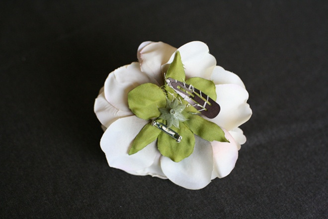 Để làm kẹp hoa cài tóc, bạn lật mặt sau của bông hoa và khâu cây kẹp tóc vào phần cuống hoa. 