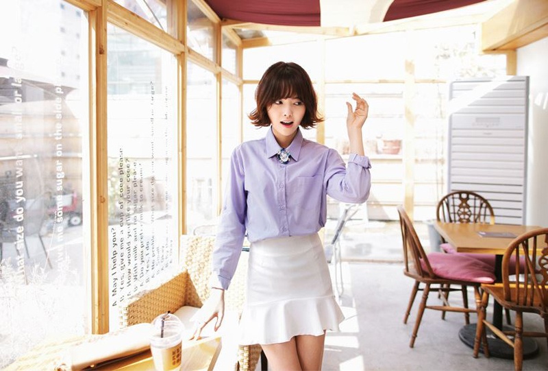 Áo sơ mi tím pastel kết hợp váy đuôi cá trắng và dây đeo cổ to bản giúp set đồ công sở thêm ấn tượng và hợp mốt.