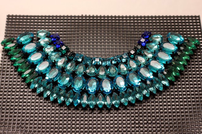 Bạn cần chọn mua các hạt crystal, hoặc các hạt nhựa giả đá quý nằm trên cùng bảng màu (ví dụ xanh lá cây, xanh biển …), và nhớ là 2 đầu các hạt đá này phải có lỗ để luồn dây.   Để chế tác chiếc vòng cổ tương tự như trong hình minh họa, Sam đã sử dụng 14 hạt crystal vuông xanh lam và xanh lá cây, 16 hạt crystal hình quả lê màu xanh ngọc, 16 hạt crystal hình bầu dục màu ngọc lam, 35 hạt đá crystal hình giọt nước xanh lá cây và xanh lam. Ngoài ra, bạn cũng cần 1 sợi dây chuyền xích mạ vàng, 1 tấm nhựa lưới màu đen, 1 cuộn dây đồng bản nhỏ, 1 cây kềm, kéo và keo E600.