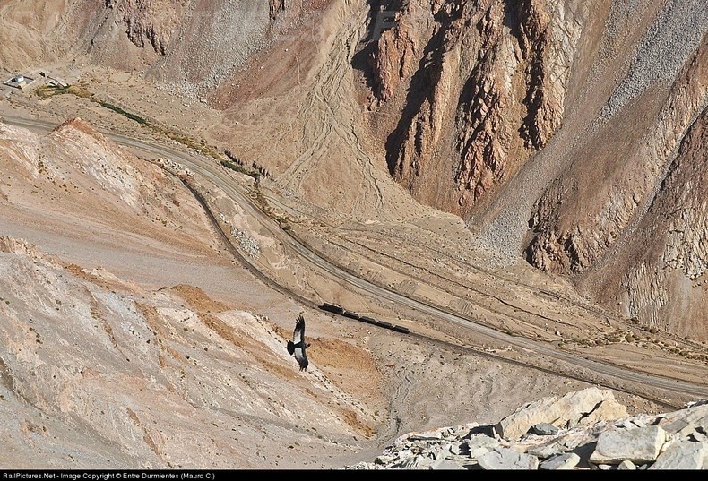 Một con tàu chở quặng đồng từ Llanta, gần Montandon – Potrerillos, trên đoạn đường ray có độ dốc tối đa 3.9%. Đoàn tàu trông như con kền kền xinh đẹp, hướng nhìn từ đỉnh núi cao của dãy Andes.