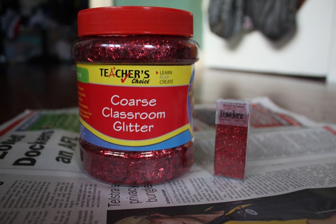 Đầu tiên, hãy sưu tầm đầy đủ các nguyên liệu đơn giản, dễ tìm sau: 1 hộp keo PVA, 1 hũ sequin đỏ (có thể thay bằng các màu sắc khác theo sở thích của bạn), giấy báo cũ, 1 cái chén nhỏ và 2 cây chổi cọ sợi to.