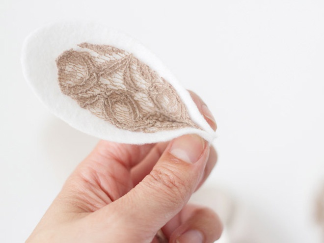 Gắp phần đầu của miếng vải nỉ để tạo thành hình tai thỏ. Thao tác tương tự với phần tai thỏ còn lại.