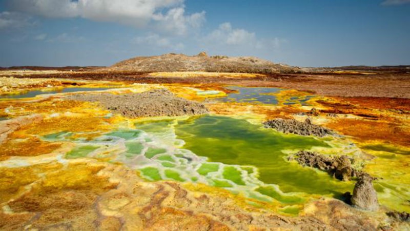 Miệng núi lửa – Ethiopia Trong ngôn ngữ của người Afar, Dallol có nghĩa là bị phân hủy. Bởi vậy, nó làm mọi người có cảm giác rằng miệng núi Dallol Volcano của Ethiopia vẫn đang hoạt động hơn là đã tắt thực sự. Nguyên nhân là do sự pha trộn của nước ngầm – mắc ma, lưu huỳnh, oxit sắt, muối và các khoáng sản khác đã tạo ra màu xanh sống động và màu vàng neon, hình thành một trong những cầu vồng tự nhiên xa xôi, hoang sơ nhất trên thế giới. 