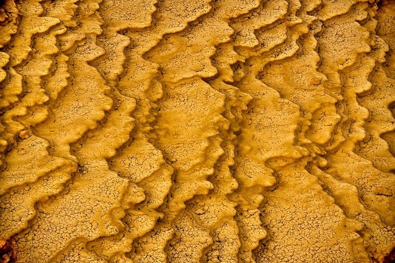 Con suối nước nóng bậc thang Badab-e Surt mang màu sắc cam sáng và đỏ là chủ yếu. Nguyên nhân là do có sự hiện diện của một lượng lớn trầm tích sắt oxit.