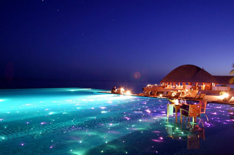 Khu nghỉ dưỡng Huvafen Fushi ở Maldives xây dựng một bể bơi buổi tối tuyệt đẹp với ánh đèn màu lấp lánh bên dưới mặt hồ.