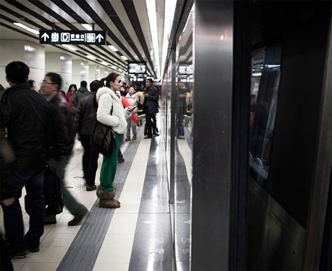 Các mẫu ô tô thường sử dụng những phương tiện công cộng thay cho taxi vì cước taxi khá cao so với thu nhập của họ. Trong ảnh là mẫu ô tô Du Yifei đang chờ chuyến tàu điện ngầm để đến trung tâm triển lãm vào khoảng 6 giờ sáng mỗi ngày.