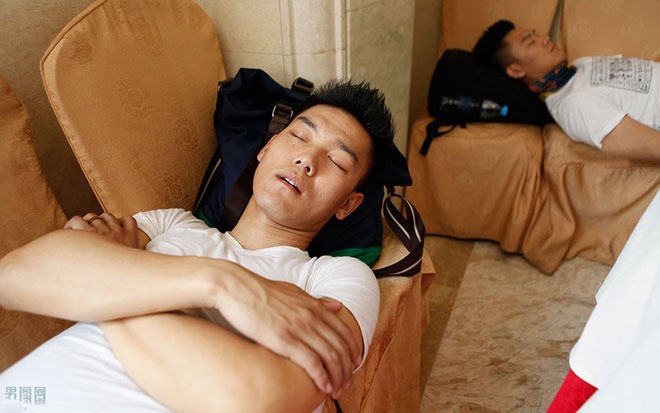 Hai anh em sinh đôi mệt mỏi nghỉ lưng sau khi đáp chuyến tàu lưu diễn tại một tỉnh lân cận thành phố Hà Nam.