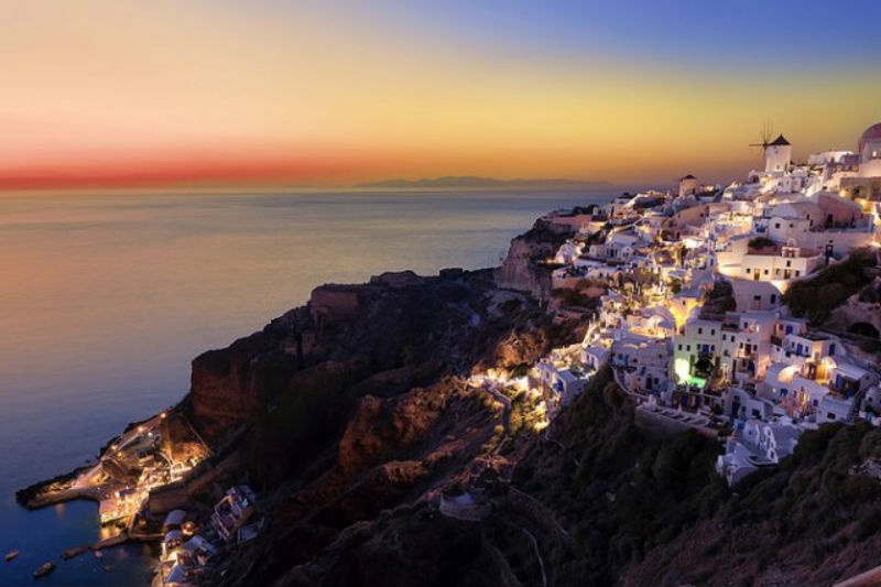 1. Thị trấn Fira và Oia, Santorini, Hy Lạp: Santorini là một hòn đảo núi lửa thuộc quần đảo Cyclades ở Hy Lạp. Nó nổi tiếng với những quang cảnh gây ấn tượng mạnh như cảnh hoàng hôn tuyệt đẹp từ các thị trấn Fira và Oia, những ngôi nhà được quét vôi trắng tinh và ngọn núi lửa vẫn còn đang hoạt động rất riêng của nó.  Oia được xây dựng ở phía trên đỉnh của những vách đá hùng vĩ nhìn ra một ngọn núi lửa bị ngập chìm dưới mặt nước biển. Còn vùng thủ phủ Fira là một sự kết hợp về kiến trúc giữa người Venetian và Cycladic, những con đường rải đá sỏi trắng với các cửa hàng vô cùng nhộn nhịp trong khi chúng đang nằm bám chặt vào các bờ vực của thành phố nằm trên vách đá cao 400m. 