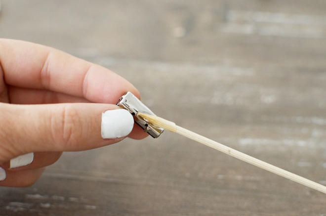 Đầu tiên, cho 1 ít keo ra giấy và dùng đầu tăm thoa keo vào mặt sau của viên đá.