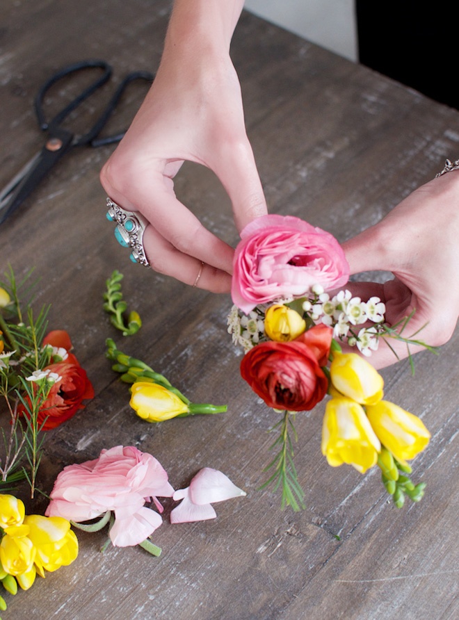 Chèn vài đóa hoa cúc baby trắng xen kẽ các loại hoa to bản khác theo thứ tự thấp dần và dùng kẽm cố định chúng vào nhánh hoa đầu tiên.