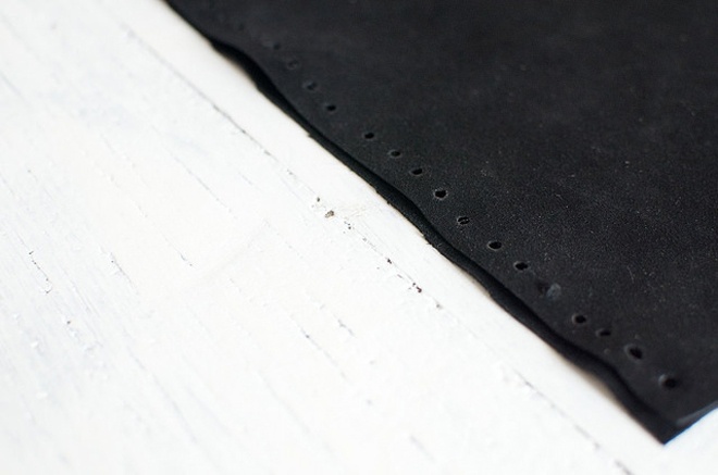 Bắt tay vào việc bằng cách gấp đôi miếng vải da, dùng kềm bấm các lỗ nhỏ và đều trên 2 cạnh bên của miếng vải.