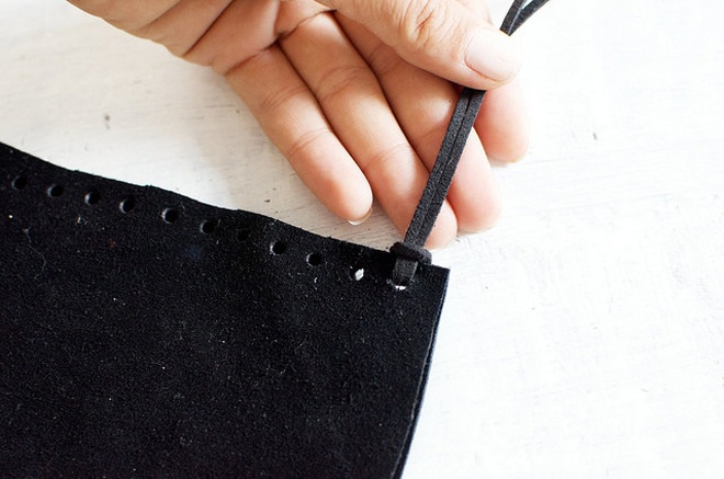 Gấp đôi sợi dây da thành 2 đoạn đều nhau hoặc so le tùy sở thích của bạn, rồi luồn sợi dây vào lỗ tròn đã bấm sẵn trên miếng vải da và thắt nút đơn giản như trong hình.