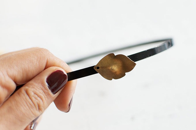 Bắt tay vào việc bằng cách cho 1 ít keo lên giấy, dùng tăm quết keo lên cài tóc và đính lá kim loại lên.