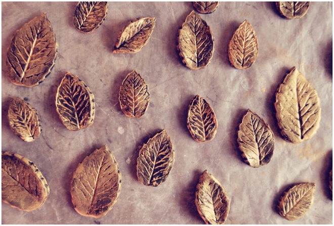 Dùng keo màu ánh kim phết lên lá, sau đó xếp những chiếc lá lên 1 tờ giấy chờ keo khô.