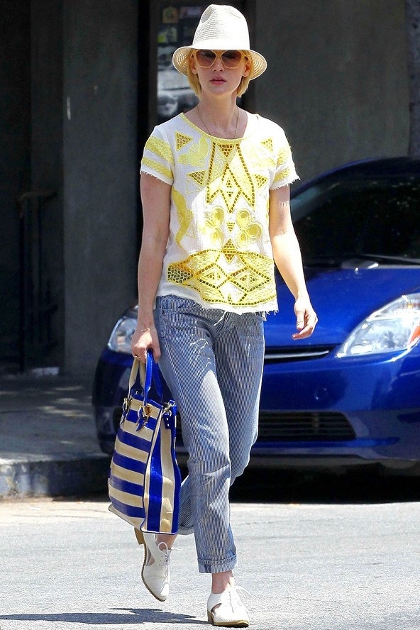 Cách mix boyfriend jeans với áo họa tiết màu vàng, túi sọc xanh trắng và đôi giày cut-out khiến January Jones trông trẻ trung, tươi mới hơn rất nhiều.