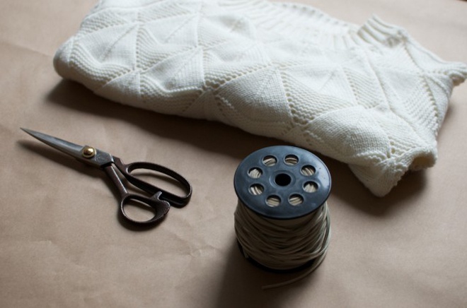 Đầu tiên, bạn cần sưu tầm đầy đủ nguyên vật liệu như 1 chiếc áo len cũ có đường móc hình thoi, một cuộn dây da sợi mảnh, 1 chiếc kéo.