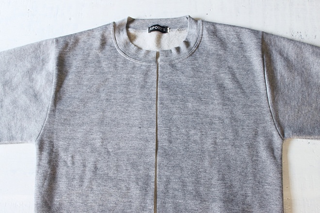 Bắt đầu bằng cách gấp đôi chiếc áo và dùng kéo cắt mặt trước ra làm đôi theo đường gấp vừa tạo thành.