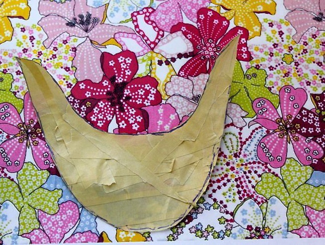 Đặt phần phom mũi giày lên miếng vải in hoa, sau đó dùng kéo cắt theo kích thước có sẵn.