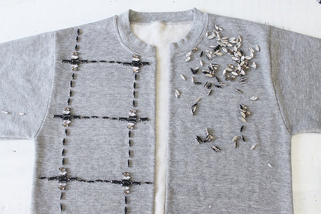 Dùng thước và bút chì trắng kẻ các đường trang trí trên mặt trước của áo theo sở thích, có thể là các hình thoi, tam giác hoặc hình vuông, sau đó sắp xếp hạt đá lên những đường kẻ để tạo thành các chi tiết trang trí ấn tượng.