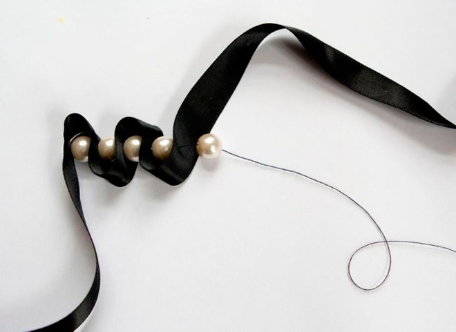 Thắt nút sợi chỉ sau khi kết ngọc trai vào khoảng 2/3 chiều dài sợi dây ruy băng.