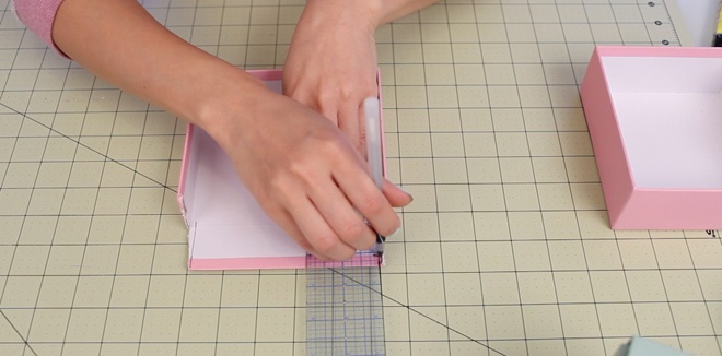 Bước 1. Dùng thước kẻ cố định và lấy dao rọc giấy cắt 2 mặt bên của nắp hộp giấy như hình minh họa.