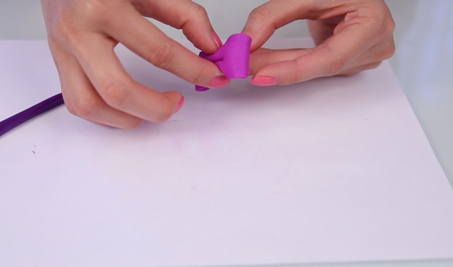 Dùng tay bóp nhẹ 2 thành bên của miếng đất sét để tạo thành hình chiếc nơ nhỏ.