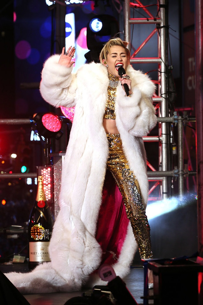 Miley Cyrus đã quậy tưng sân khấu mừng năm mới 2015 vừa qua với một kiểu mix trang phục đông xuân không đụng hàng: áo lông thú dài thậm thượt và áo crop top liền quần ánh kim lấp lánh.