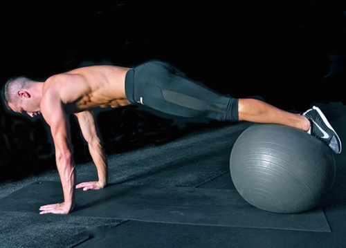 Bài tập 6: Sử dụng một quả bóng thể dục làm dụng cụ trợ giúp. Hai bàn tay chống thẳng xuống sàn đồng thời đặt hai chân lên quả bóng.