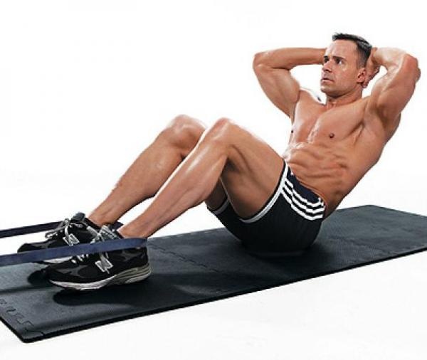 3. Janda sit-up (Gập bụng chữ V): Bước 1: Nằm ngửa, đầu gối cong và đặt tay ra phía sau đầu và khóa lại bằng cách đan ngón tay vào nhau.  Bước 2: Giữ chặt gót chân dưới sàn nhà trong khi nhấc thân trên lên tao thành chữ V với đùi. Dừng lại 1-2 giây sau đó từ từ hạ thân trên xuống vị trí bắt đầu. Thực hiện động tác này 12 lần. Ảnh: Mensfitness.