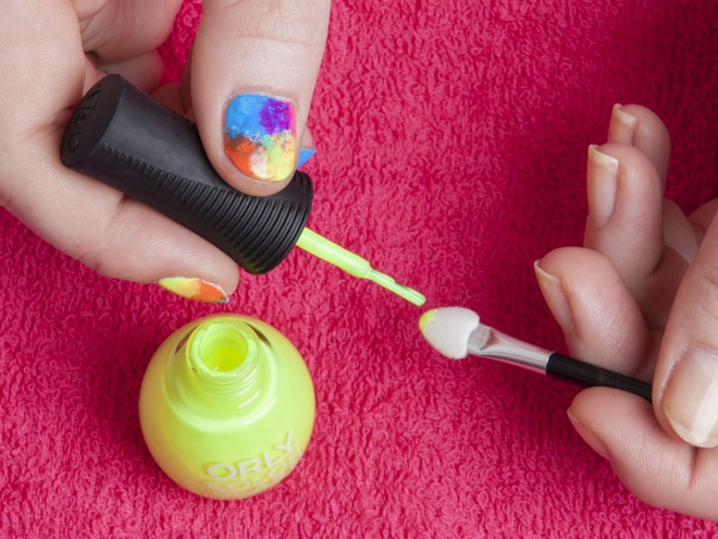Sau khi tất cả các lớp sơn này đã khô, chấm 1 ít sơn màu vàng neon lên đầu cọ. Dùng cọ phủ màu vàng lên các vùng móng còn loang lỗ để tạo thành kiểu nail hoàn chỉnh.