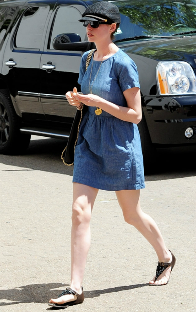 Nữ diễn viên Anne Hathaway năng động trong bộ váy denim phối túi to bản, mũ lính chì và dép xỏ ngón đính đá.