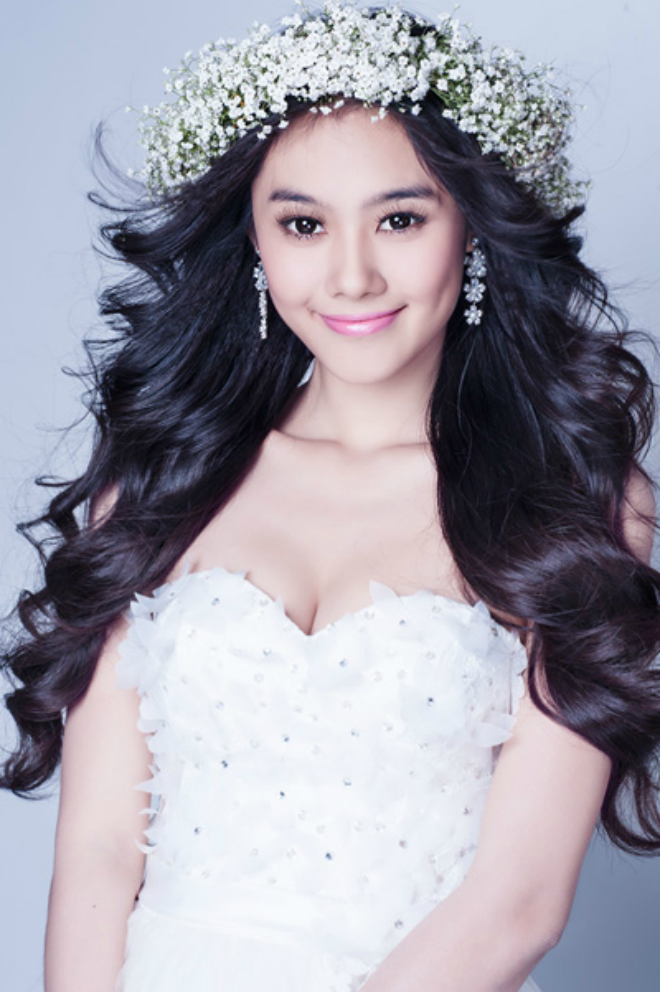 Tóc xoăn buông xõa và đội vương miện bằng vòng hoa phù hợp với những cô dâu yêu thích sự đơn giản, nhưng không kém phần năng động.