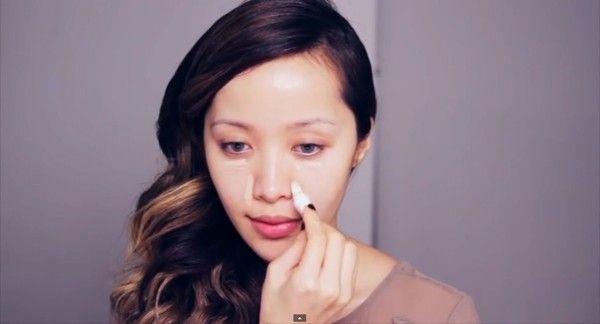 Bước 1: Nếu bạn có làn da hoàn hảo, bạn có thể bỏ qua bước kem nền và sử dụng ngay kem che khuyết điểm tại quầng mắt, cánh mũi và khóe miệng tán đều bằng cọ nhỏ tạo lớp nền mỏng mịn.