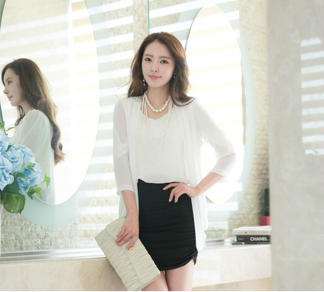 Set đồ công sở thanh lịch cùng chân váy đen và sơ mi trắng sẽ điệu đà hơn với sự kết hợp của chiếc cardigan tay voan khoác ngoài, kiểu áo dáng dài được thiết kế không cúc tạo độ nữ tính hơn cho nữ công sở.