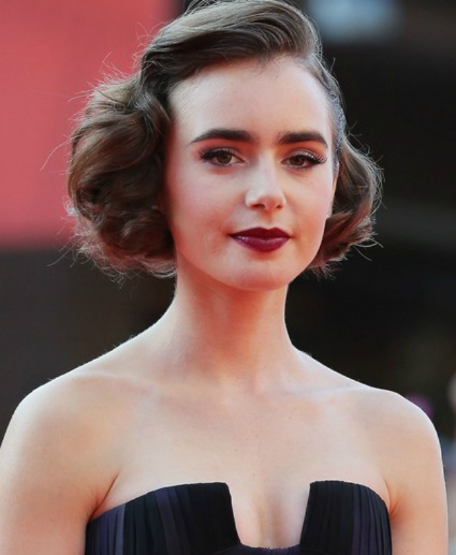 Lily Collins lạ lẫm với hình mẫu của thập niên 50 với son môi tông màu đỏ đậm.
