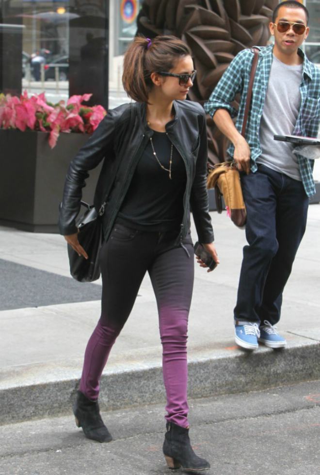 Nina Dobrev cá tính và mới lạ khi diện jeans tông màu ombre đen-tím với áo phông, jacket và bốt cùng tông màu đen.
