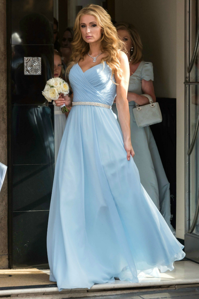 Paris Hilton làm phù dâu xinh đẹp, nổi bật tại lễ cưới của em gái. Ngôi sao 34 tuổi buông xõa mái tóc vàng óng ả, mặc đầm xanh nước biển thướt tha, trên tay cầm một bó hoa trắng.