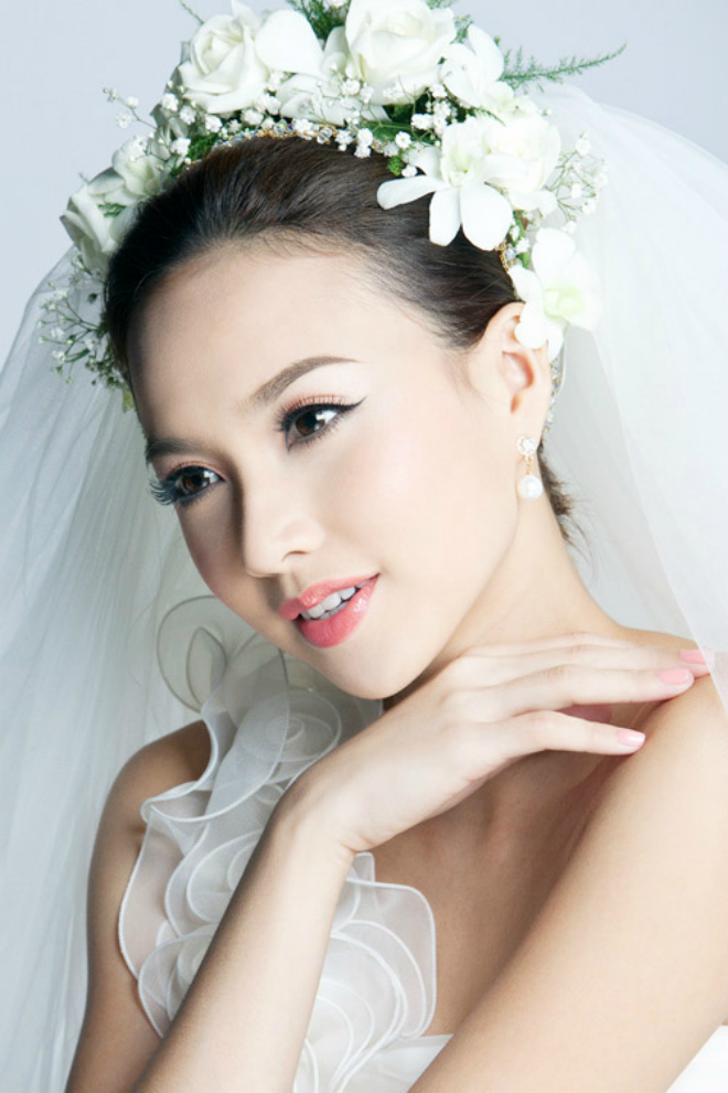 Cô dâu kết hợp hoa cài với khăn voan để tạo điểm nhấn và tôn được chiều cao.