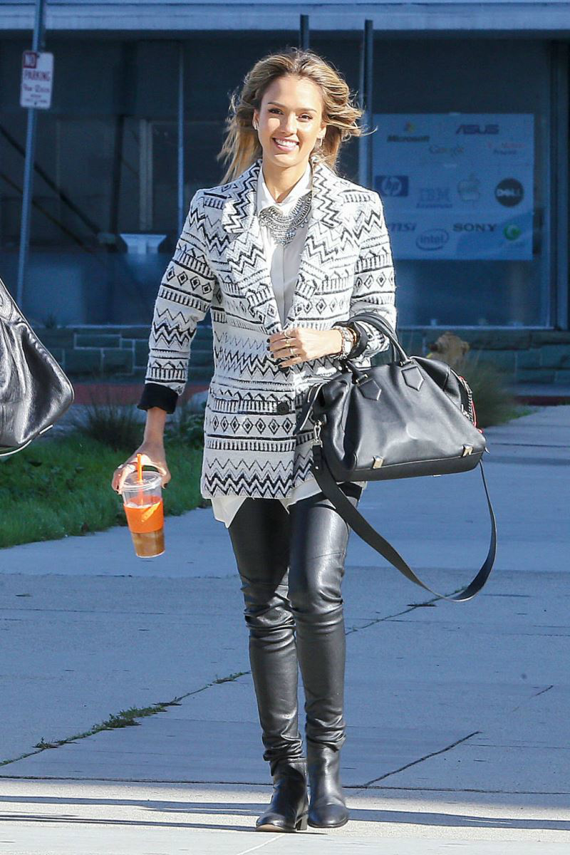 Jessica Alba mang sự sinh động vào bộ đồ của mình bằng cách kết hợp quần legging da với áo khoác nhiều họa tiết cùng chiếc túi Thakoon.