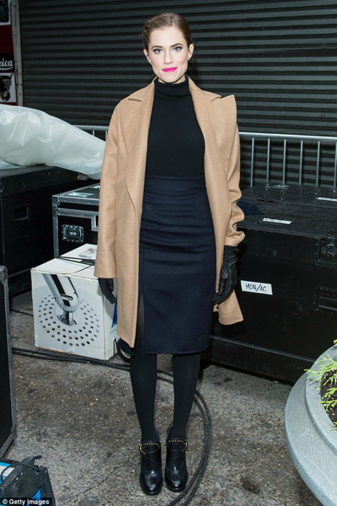 Allison Williams đón cái gió lạnh mùa đông với áo khoác màu lông lạc đà mặc bên ngoài một chiếc áo len cổ lọ màu đen và chân váy bút chì màu xanh hải quân. Những phụ kiện cô lựa chọn bổ sung là găng tay da, quần tất đen dày và bốt thấp cổ kiểu phong cách đua xe. 