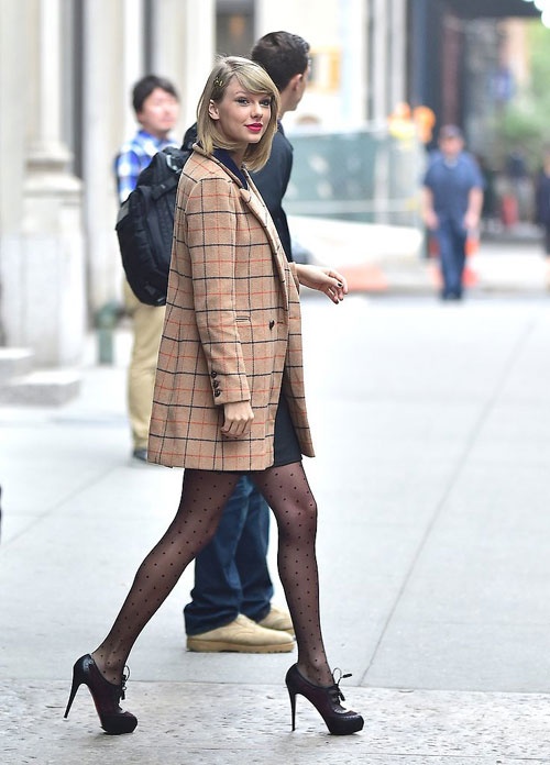 Áo khoác kẻ ô to dáng blazer thanh lịch được Taylor Swift mix cùng váy suông và giày cao gót tối màu.