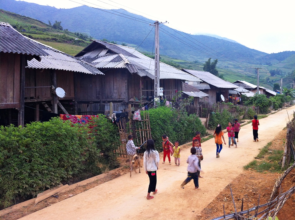 Xế chiều, đám trẻ trong bản ùa ra sân chơi. Bản khá khang trang với con đường bê tông sạch đẹp, nhiều nhà đã có ti vi, có truyền hình vệ tinh
