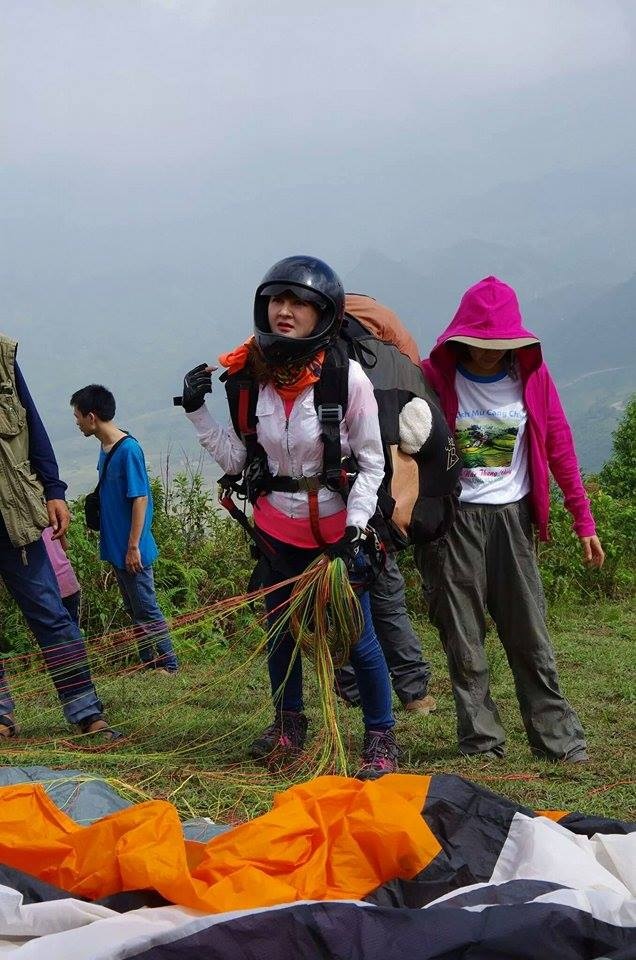 Chuẩn bị bay, Trang phải đội mũ bảo hiểm fullface bảo vệ toàn mặt và đi dày bảo vệ mắt cá chân, lưng đeo dù phụ nặng hơn 10kg