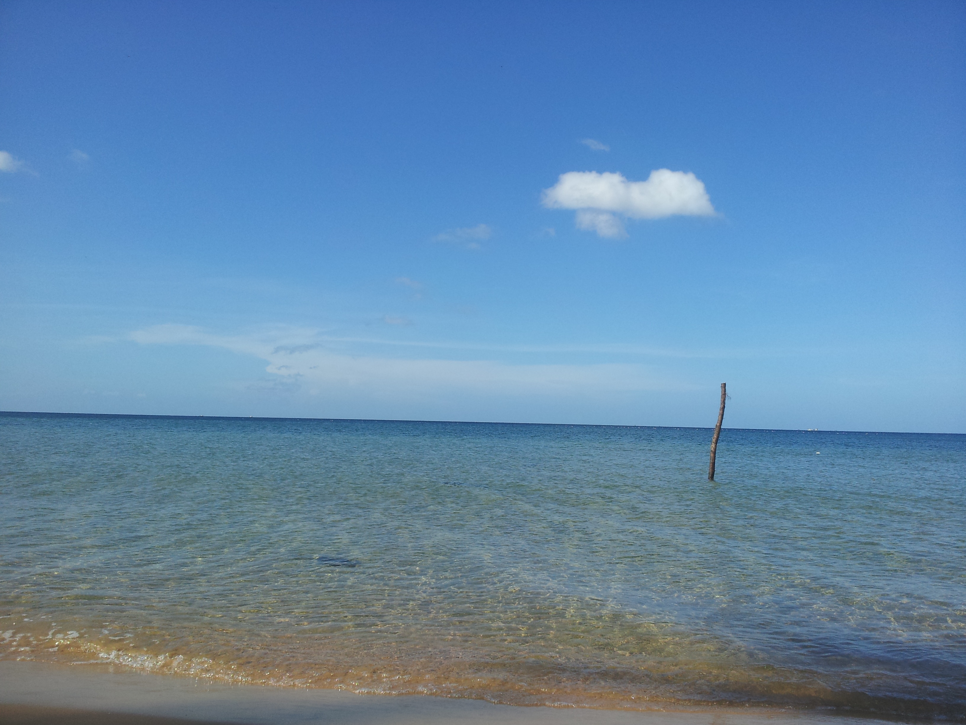 Một Bãi Trường trong xanh, cát vàng mịn óng ả với sóng nhẹ nhấp nhô.