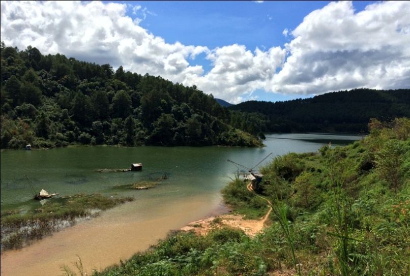 phía bên kia là dòng sông hiền hòa, êm trôi chảy dọc theo còn đường đèo xanh ngát một màu.