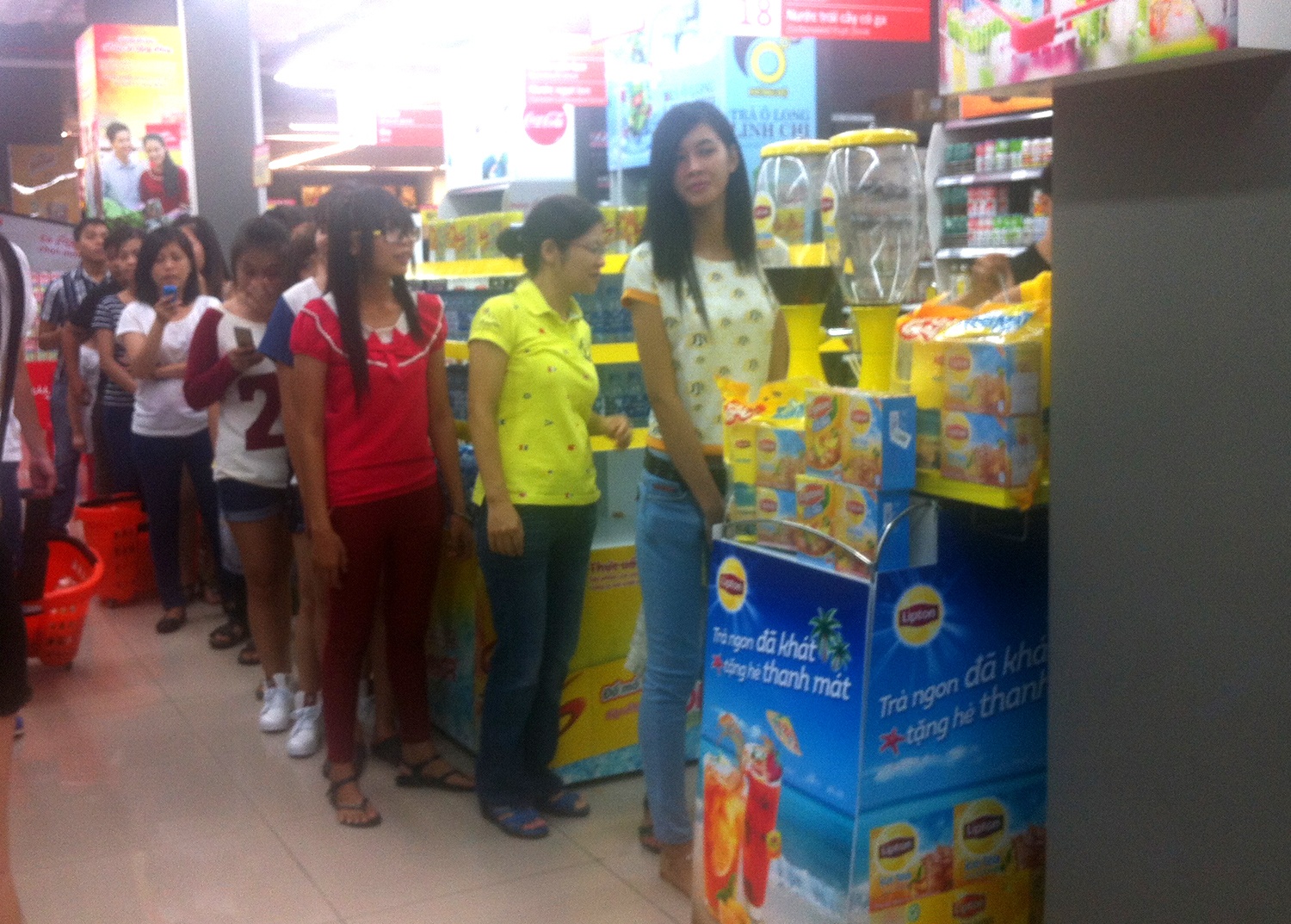 Xep hang nhan qua, nuoc uong mien phi o sieu thi Sai Gon hinh anh