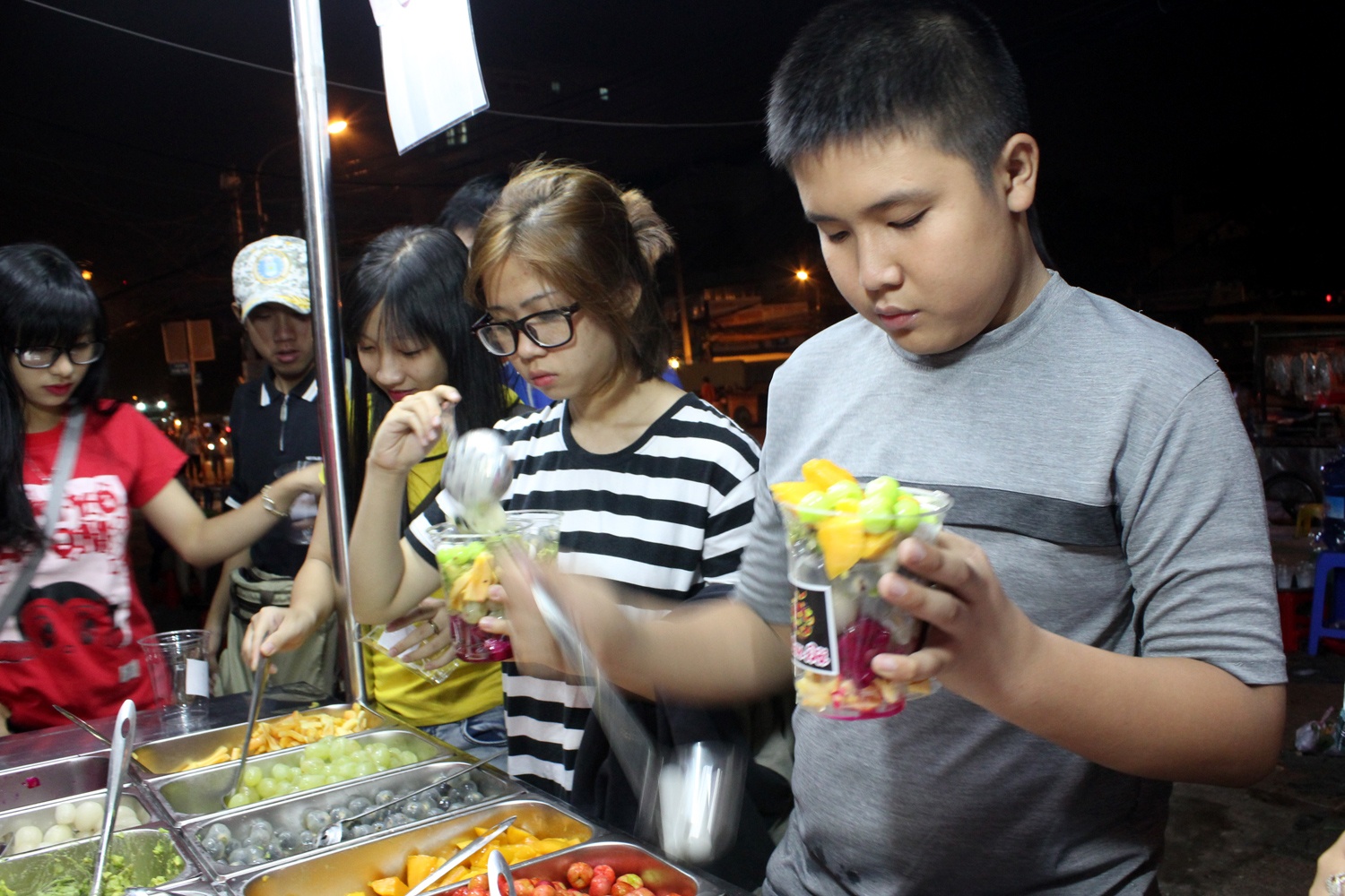 Xep hang cho an buffet trai cay o via he Sai Gon hinh anh