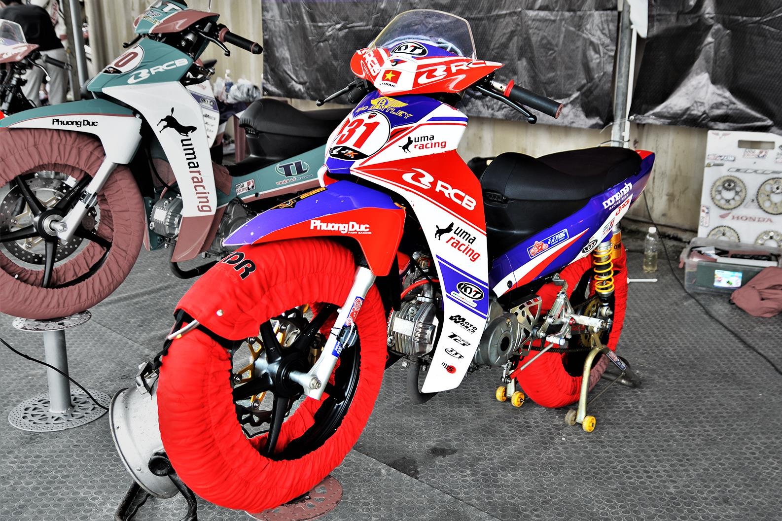 Tai sao lop xe dua phai duoc boc kin va ham nong truoc khi thi dau? hinh anh