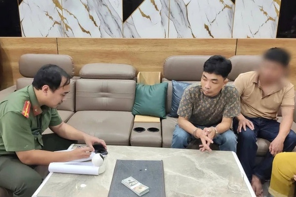 Bat 2 nguoi dan ong tang tru, luu hanh tien USD gia hinh anh